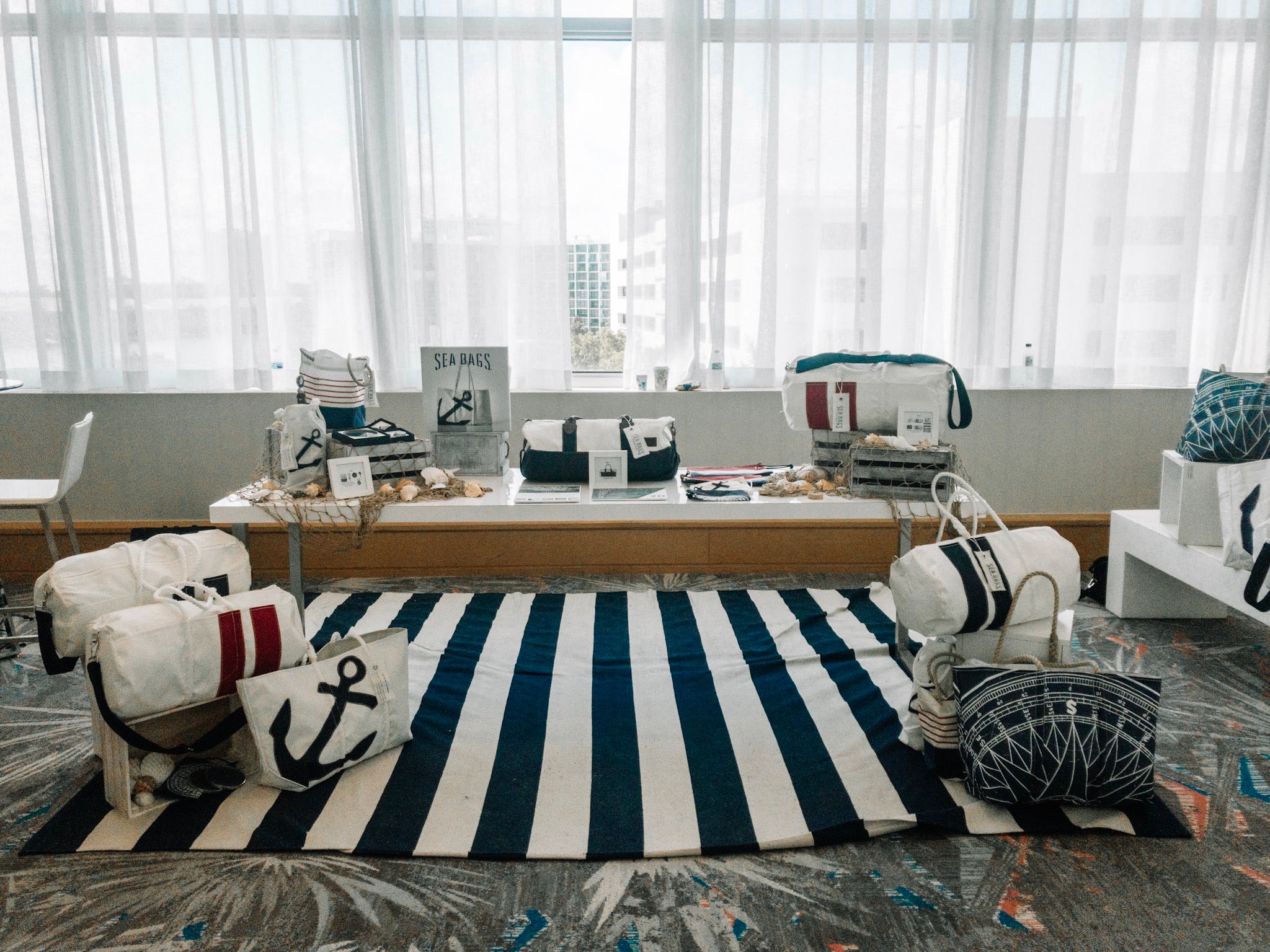 Display of nautical-themed bags on striped rug