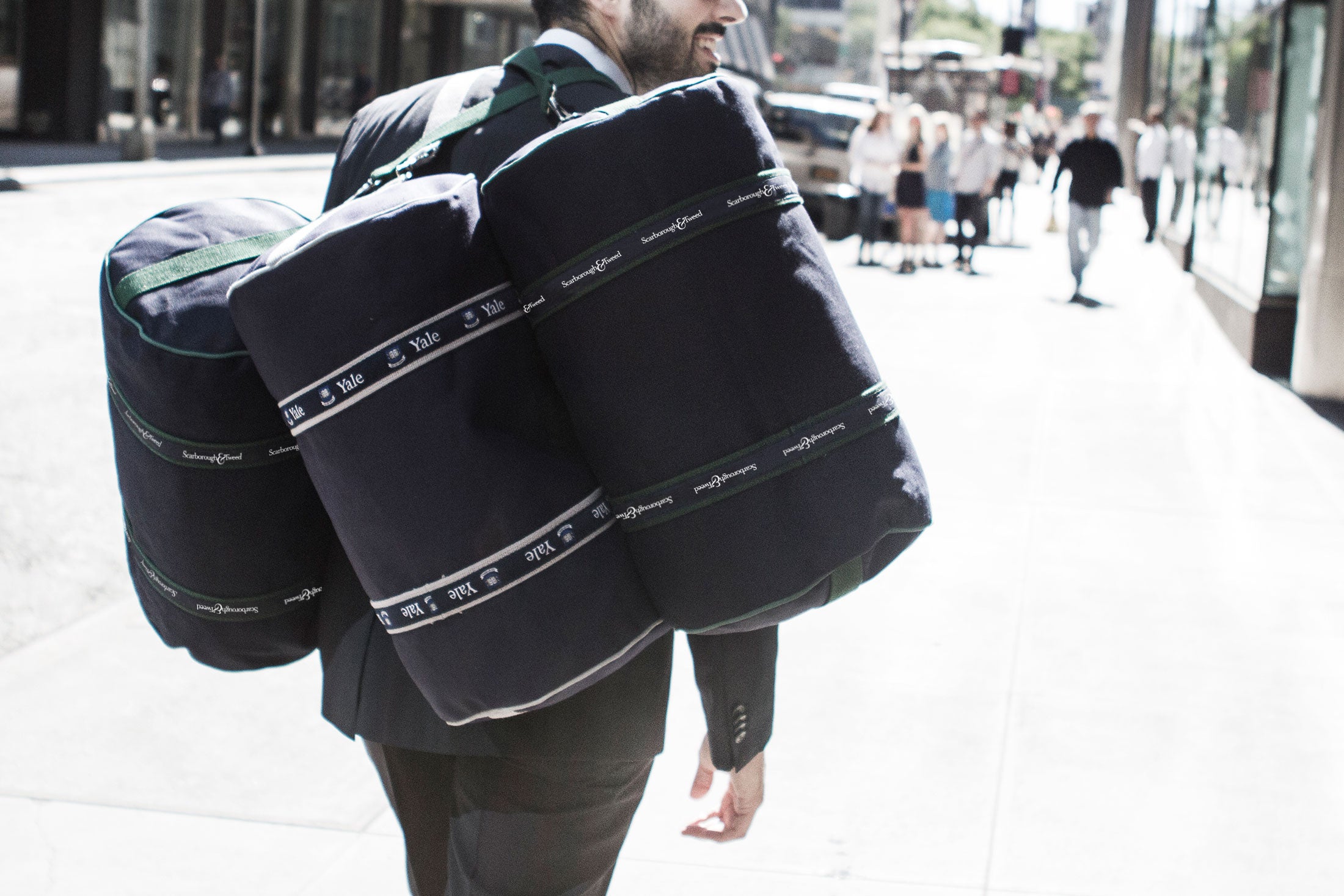 Person carrying multiple Yale banker bags with logos.