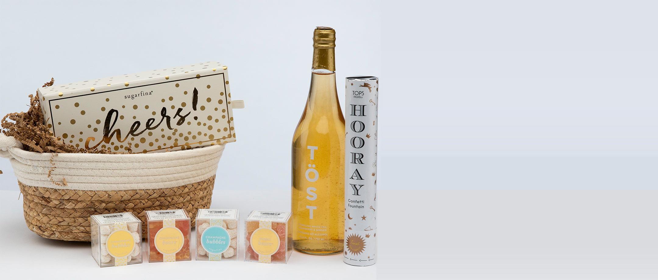 Celebration gift set with wine, sweets, and confetti.